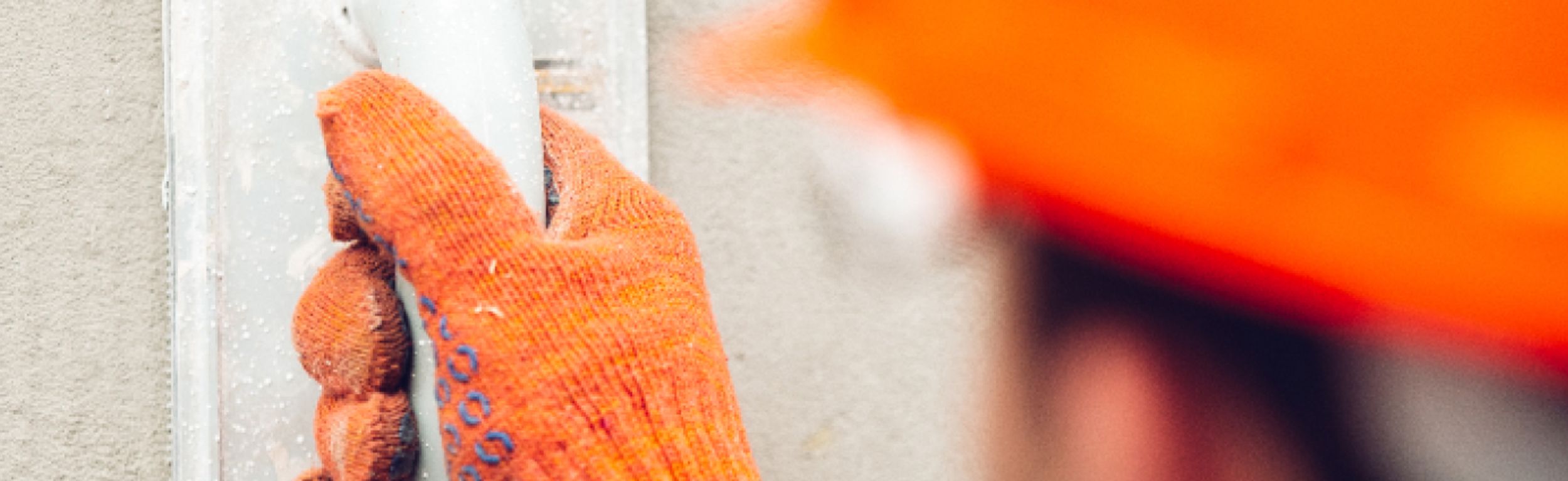 Man with orange gloves working on walls