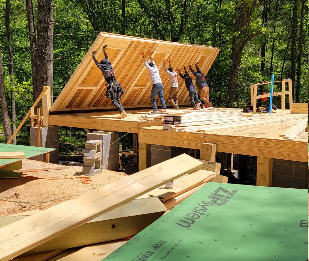 Blueprint Builders crew raising a framed wall on a residential construction site